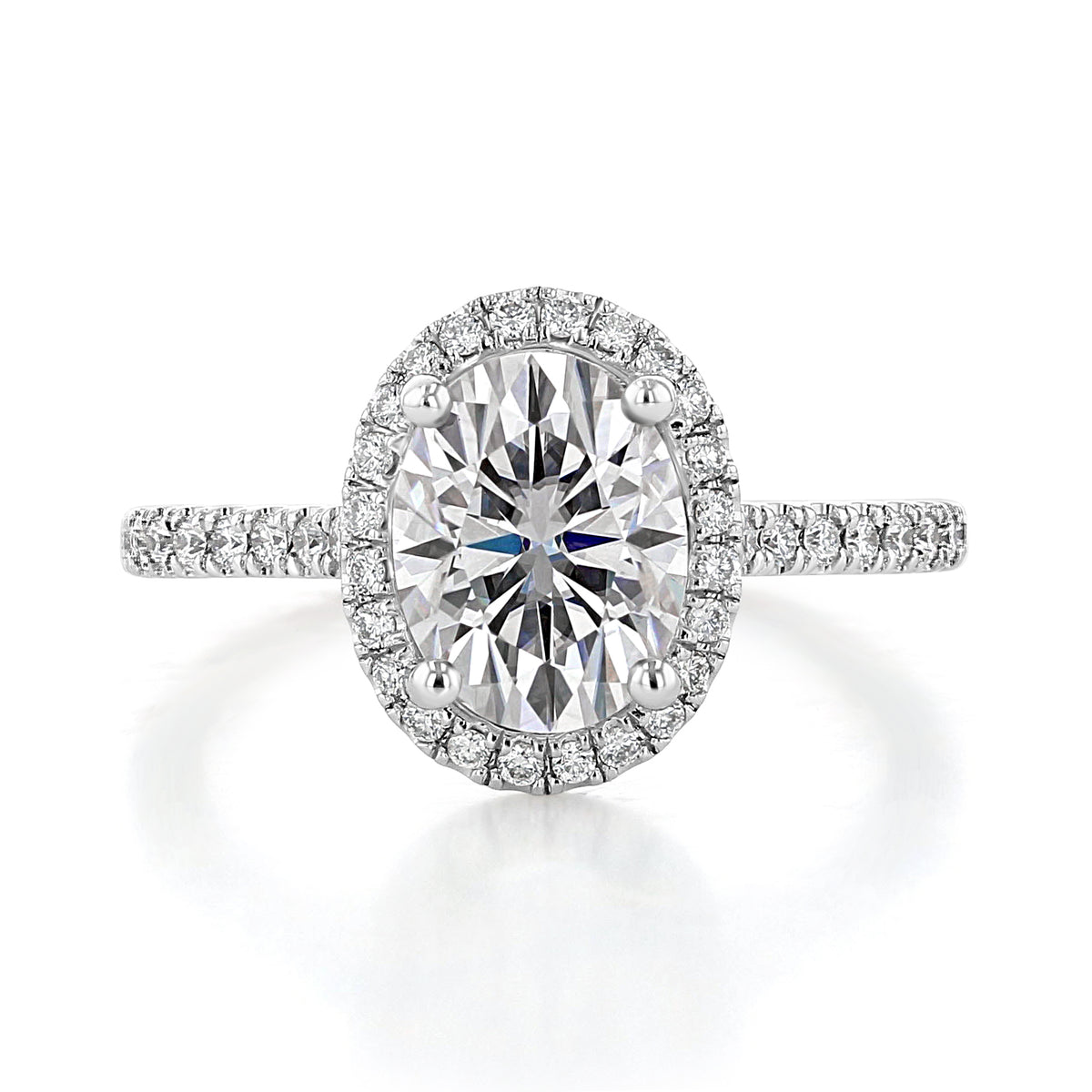 Daphne | Oval Halo Engagement Ring featuring an oval center diamond surrounded by a halo of small pavé diamonds, set on a thin band with pavé diamonds along the sides.