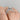 A Petite Crescent | Round Solitaire Engagement Ring - HT2558RD7W featuring a round solitaire diamond with ornate, sculpted detailing along the band and setting, worn on a finger.