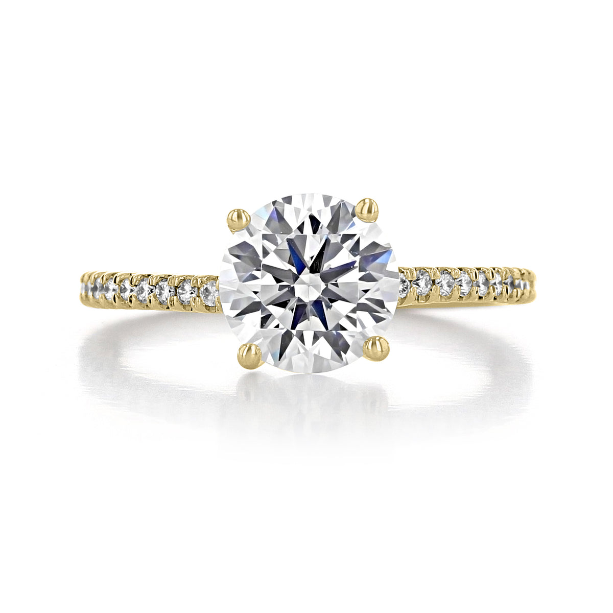 Sierra | Round Micro-Prong Engagement Ring in gold, featuring a large round-cut center stone held by four prongs with smaller pavé diamonds set along the micro-prong band.