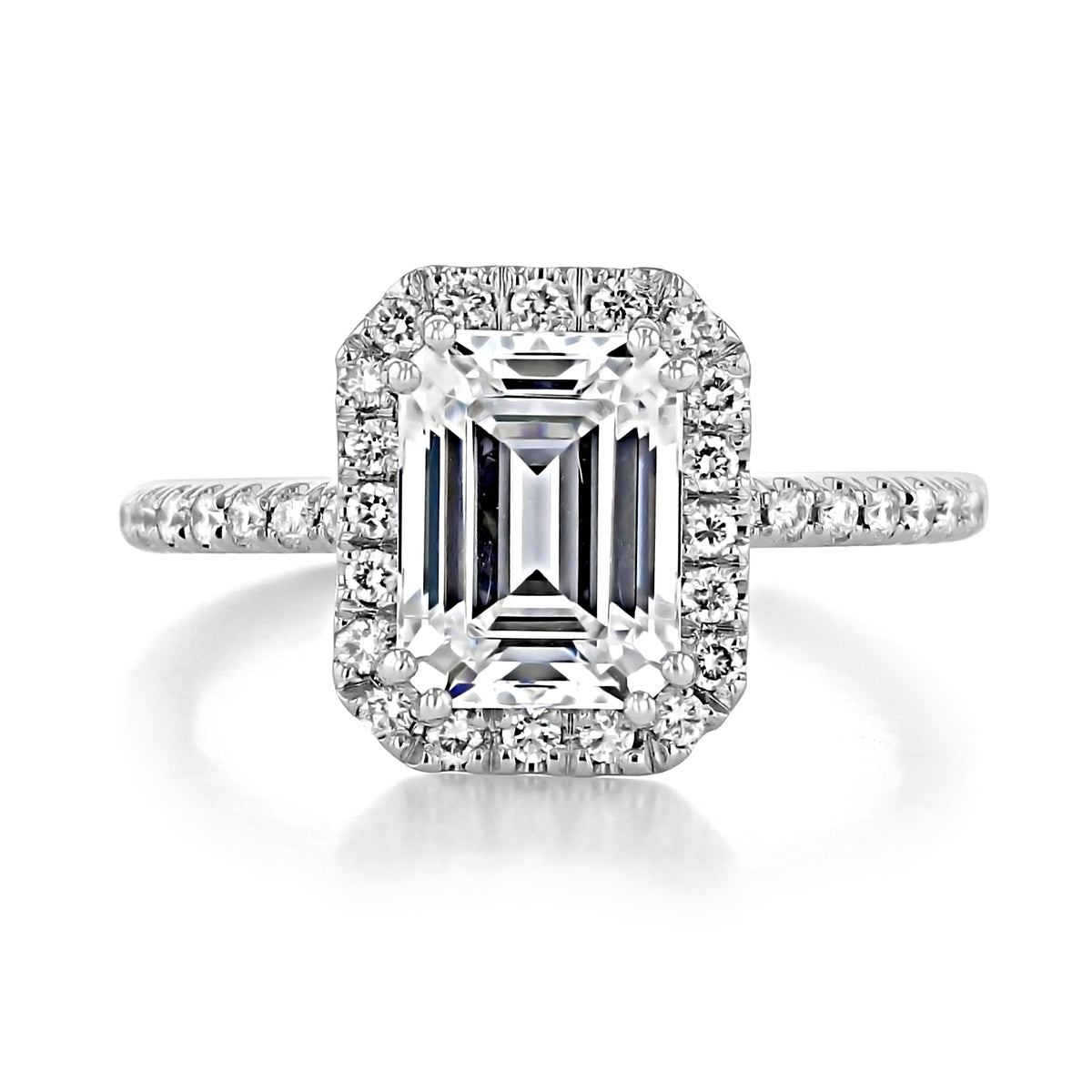 Mae Emerald Halo Engagement Ring featuring an emerald-cut center stone framed by a halo of smaller round diamonds on a micro-prong set pavé band.
