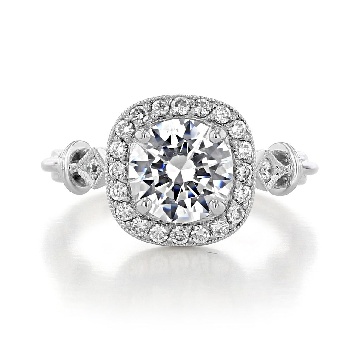 Vienna | Round Halo Engagement Ring featuring a round center diamond, a cushion-shaped halo of diamonds, and decorative filigree on the band.