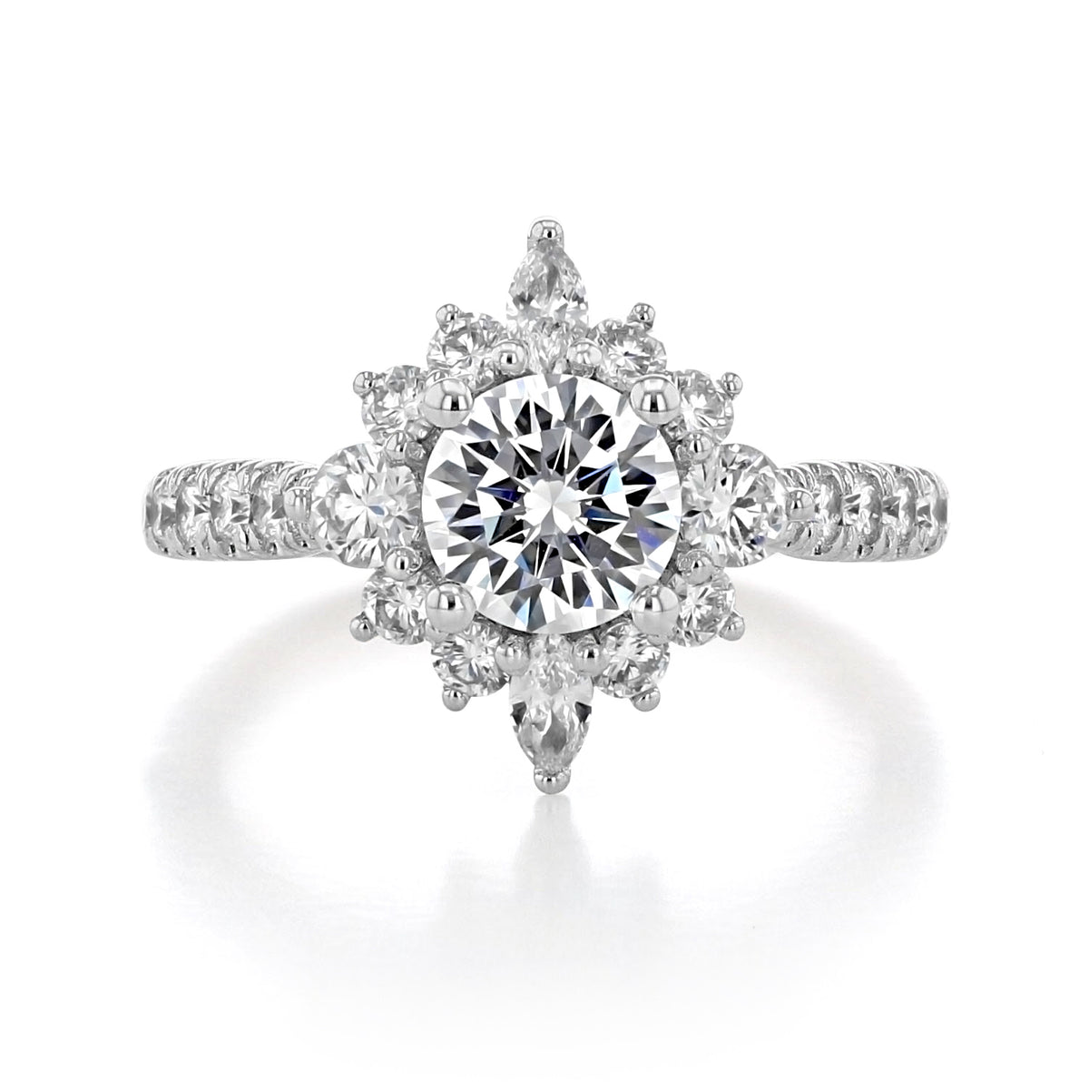The Astor | Halo Engagement Ring by Gabriel & Co. features a round-cut diamond with a celestial halo of round and pear-shaped accent stones on a micro-prong set diamond-encrusted band.