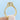Zuma | Round Halo Engagement Ring in gold with a round center diamond in a cushion halo and pavé-set diamonds along the band.
