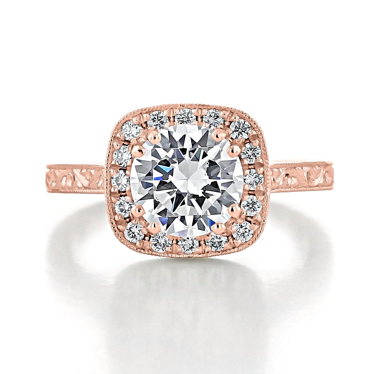 Lilia round halo engraved engagement ring featuring a cushion-shaped center diamond and an intricately engraved metal band.