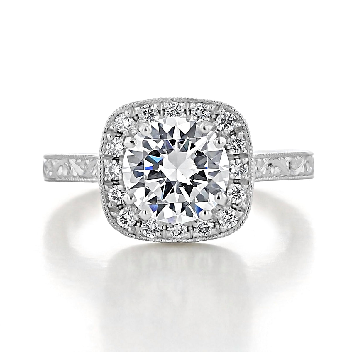 Lilia | Round Halo Engraved Engagement Ring featuring a round-cut diamond, cushion spotlight halo, and engraved details along the band.