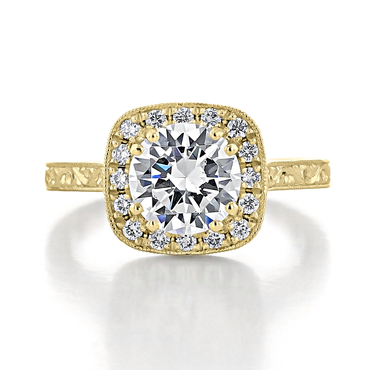 Lilia | Round Halo Engraved Engagement Ring in gold with a round center stone set in a cushion spotlight diamond halo, featuring engraved detailing along the band.