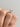 An Everly | Radiant Micro-Prong Engagement Ring by Icing On The Ring featuring a silver band with a radiant diamond center stone and a micro-prong pavé band worn on a finger.