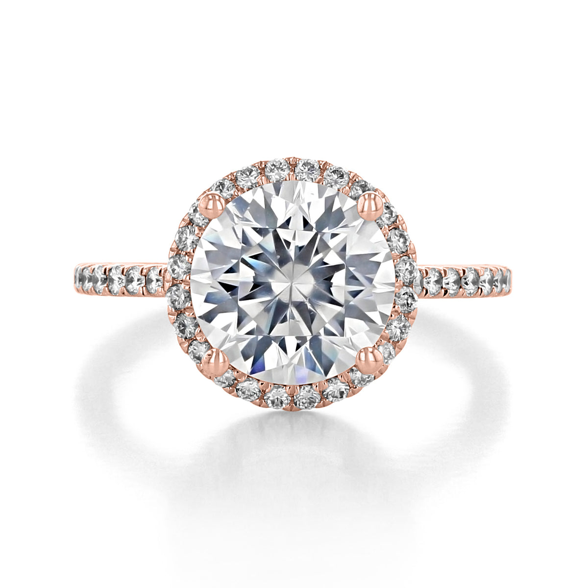 The Ora | Round Halo Engagement Ring is a rose gold ring featuring a large center diamond surrounded by micro-prong diamonds along the halo and band.