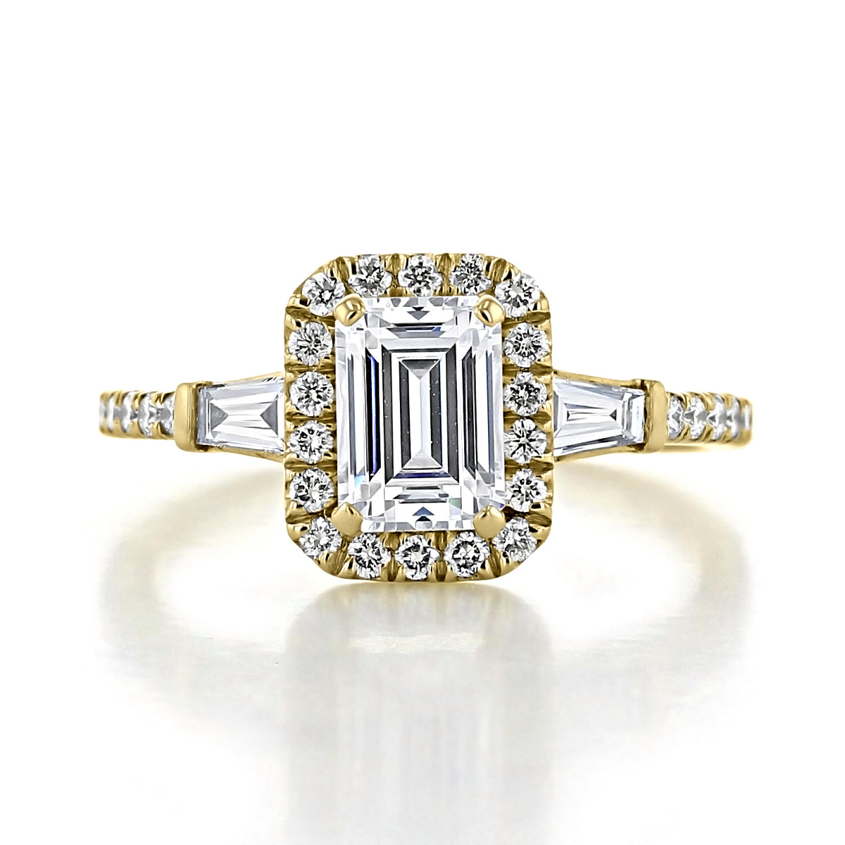 Larkin | Three-Stone Engagement Ring by Gabriel & Co. in yellow gold, featuring a central emerald-cut diamond in an art deco halo, flanked by two tapered baguette diamonds on a diamond-accented band.