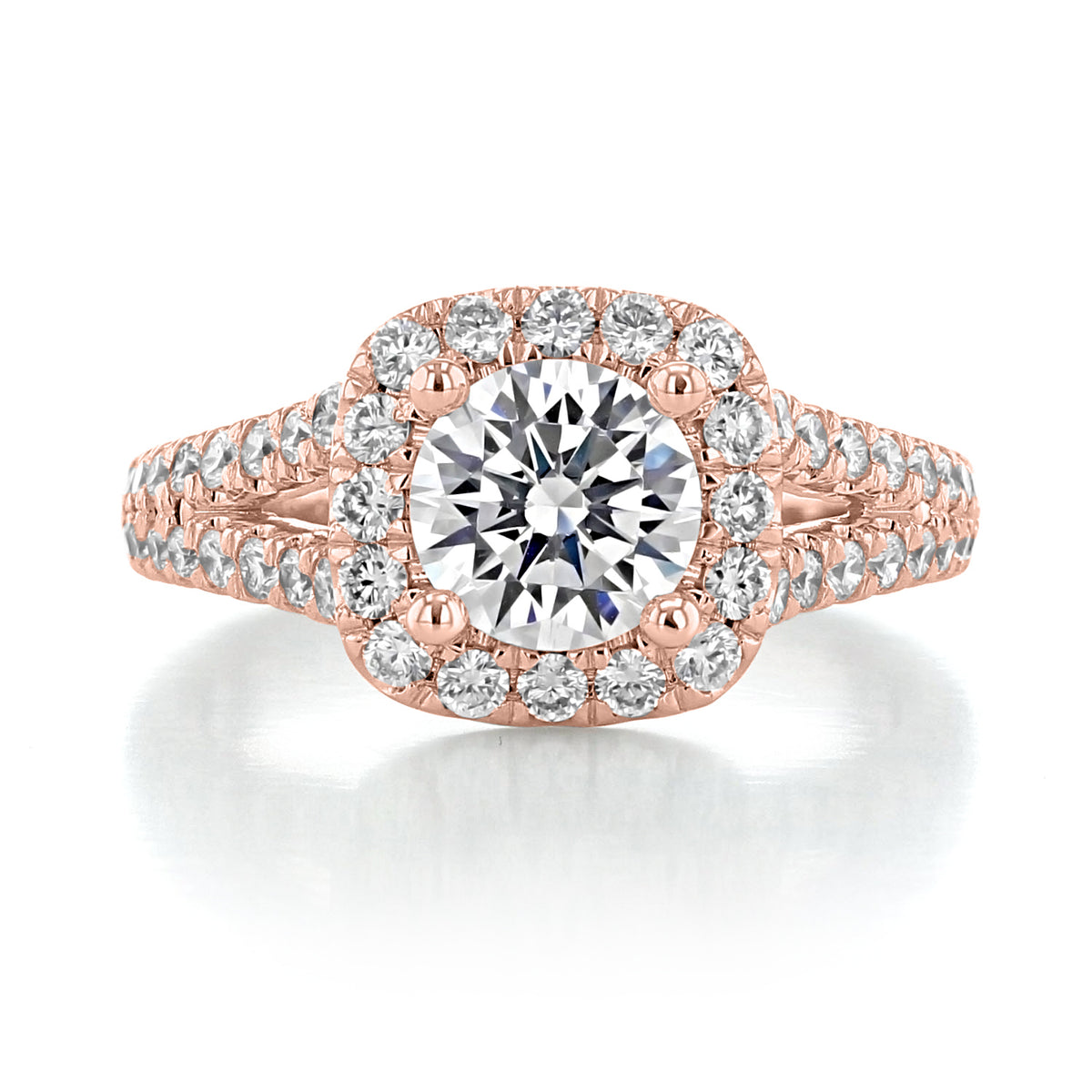 James | Halo Engagement Ring by Gabriel & Co. in rose gold featuring a round center diamond in a cushion halo on a split band accented with smaller diamonds.