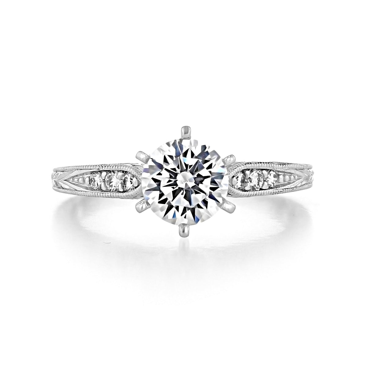 Kate | Pavé Set Engagement Ring by Gabriel & Co. featuring a Victorian era round-cut diamond, a prong-set center stone, pavé-set side diamonds, and a metallic band with engraved detailing.