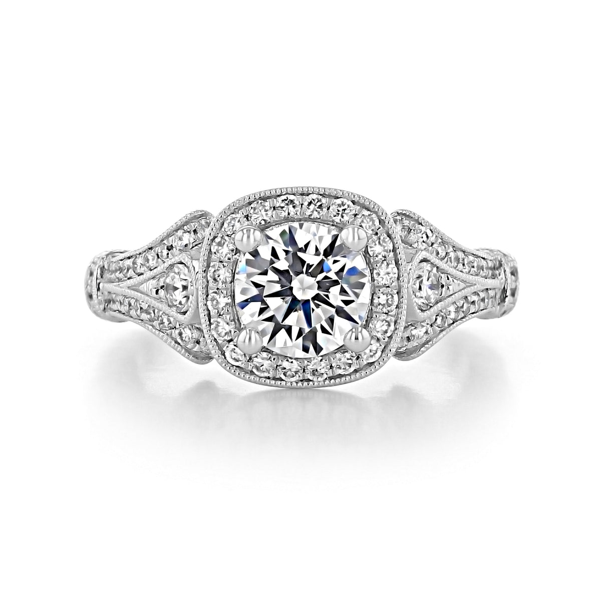 Delilah | Halo Engagement Ring by Gabriel & Co. featuring a round center diamond in a cushion halo, set on a split-shank band with milgrain and pavé accents.