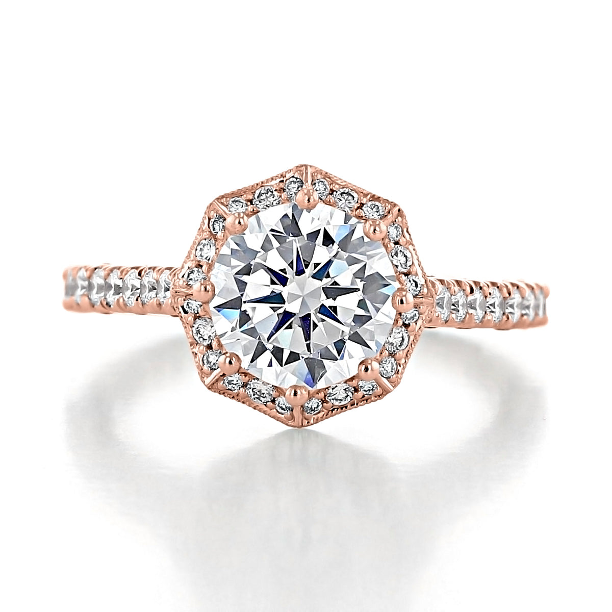 A rose gold Petite Crescent | Round Bloom Engagement Ring - HT2555RD8PK featuring a round-cut center stone surrounded by an octagon bloom of small diamonds and a pavé-set diamond band.