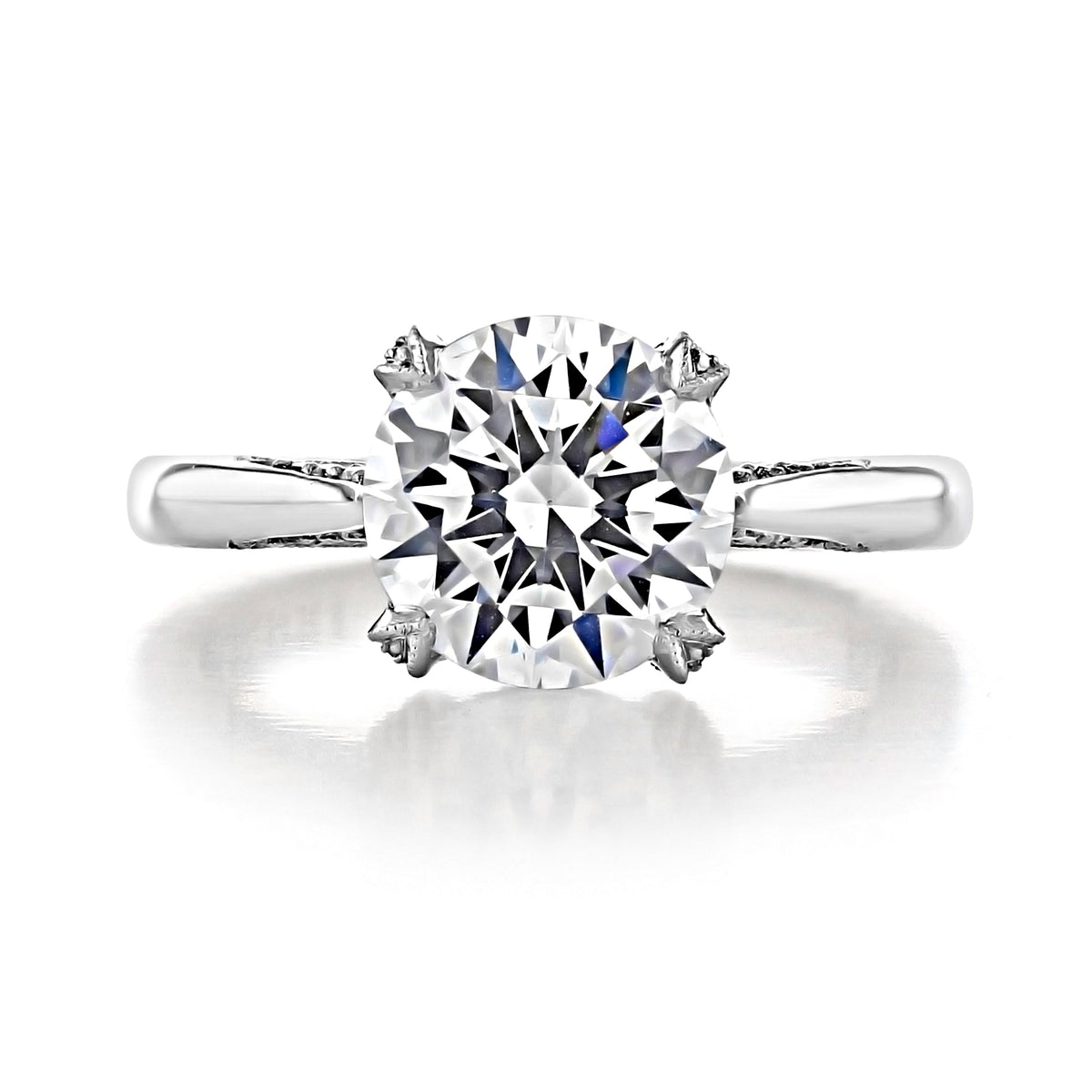 Tacori RoyalT Round Solitaire Engagement Ring - HT2625RD9 featuring a round diamond in a four-prong setting with hidden diamond accents on a polished metal band.
