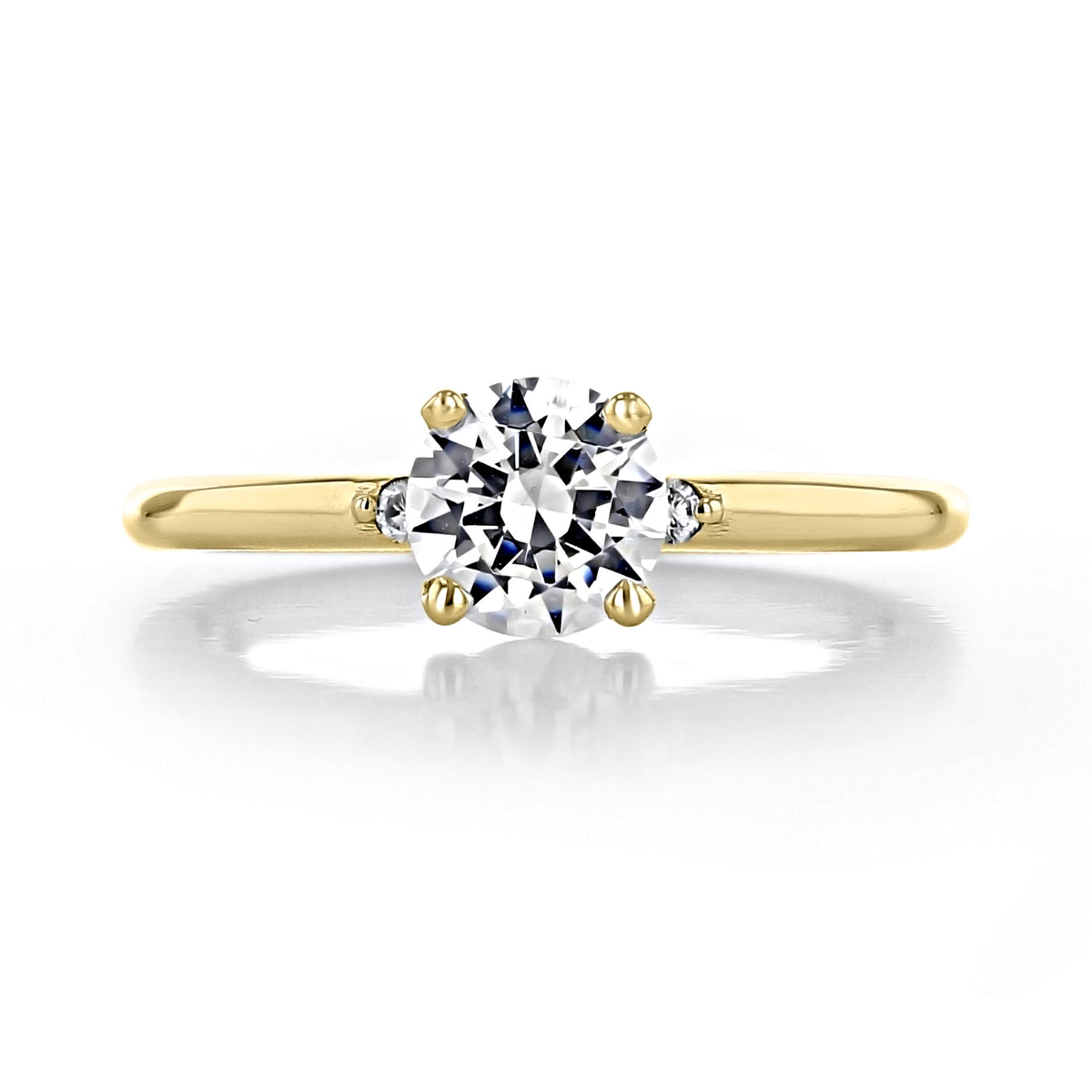 Lacey round three-stone engagement ring by Icing On The Ring featuring a 0.50 ct round center diamond flanked by two smaller round side stones.
