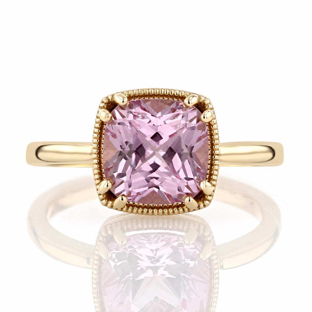 A Makur Pink Champagne Sapphire Bezel Solitaire 2006707 yellow gold ring featuring a cushion-shaped pink champagne sapphire in a beaded bezel setting.