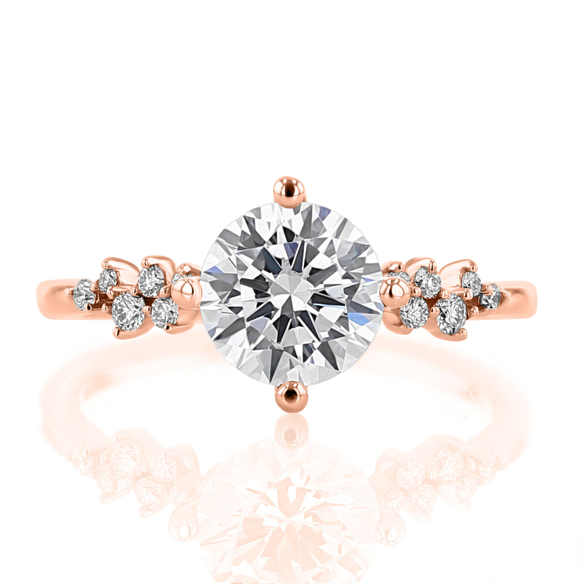 Iris | Round Cluster Diamond Engagement Ring in 14k rose gold, featuring a large round diamond centered between smaller cluster diamond accents on the band.
