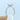 A finger wearing an Icing On The Ring Carthay Emerald Micro-Prong Engagement Ring, featuring an emerald-cut stone and a micro-prong set pavé diamond band.
