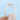 A round-cut Skylar | Round Pavé Engagement Ring by Icing On The Ring with a pavé-set band, held between two fingers.