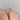 Simply Tacori round solitaire engagement ring with a micro-prong diamond pavé band worn on a finger.