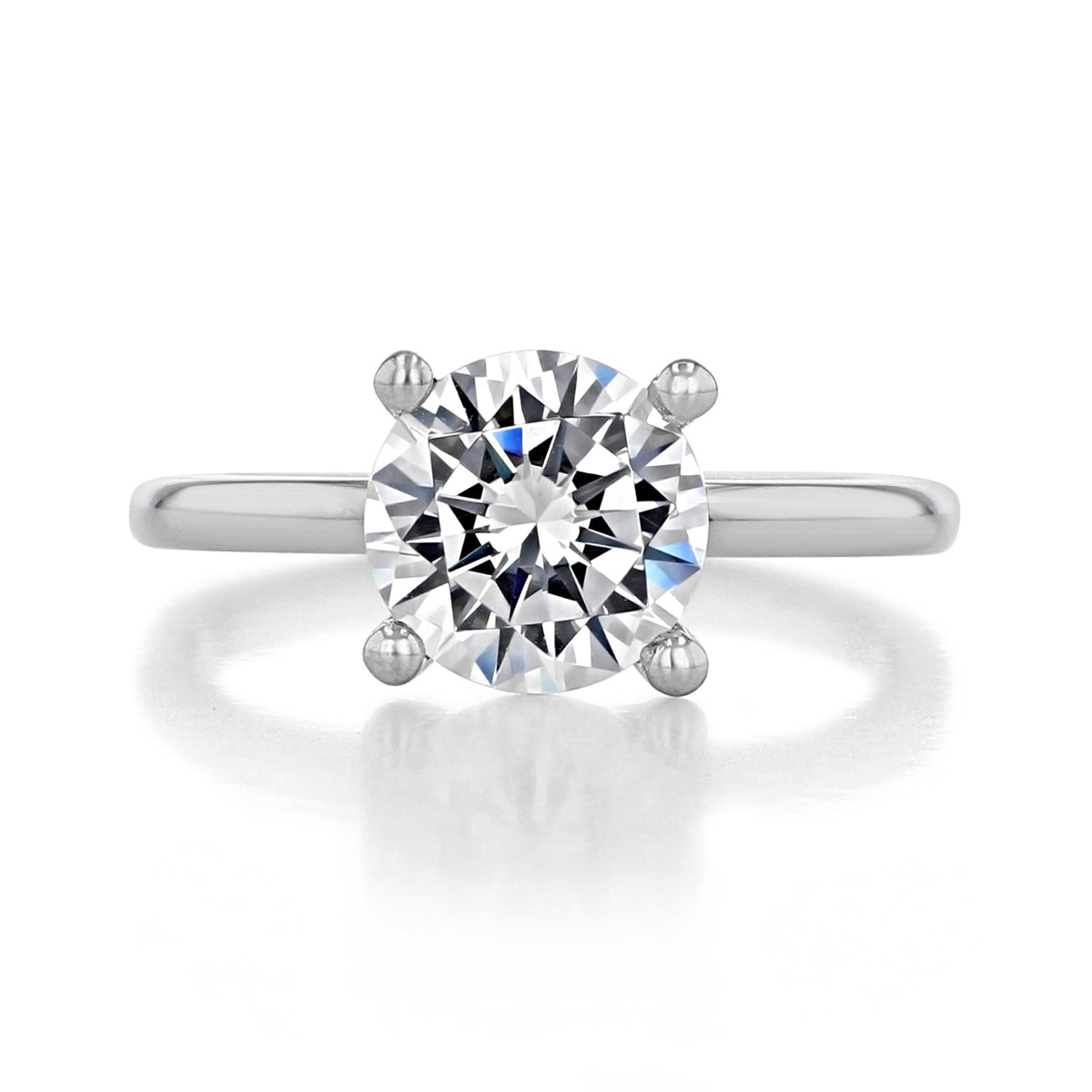 Paula | Solitaire Engagement Ring by Gabriel & Co. featuring a round center diamond on a plain silver-toned band.