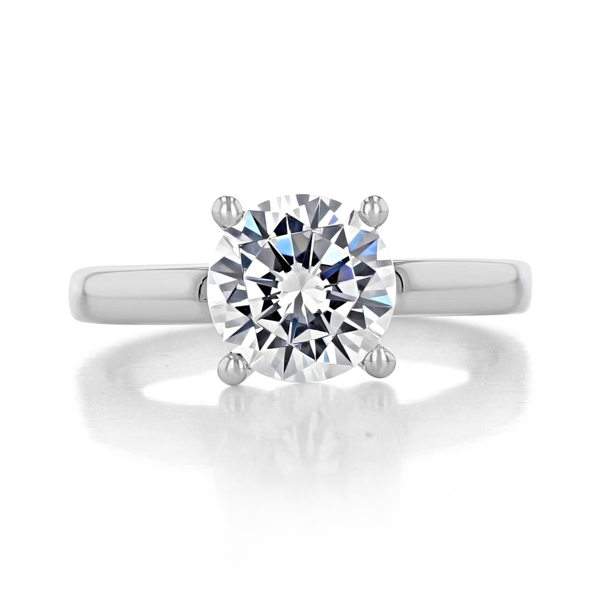 Cambria | Round Solitaire Engagement Ring by Gabriel & Co. featuring a round brilliant-cut center stone held by four prongs on a plain metal band.