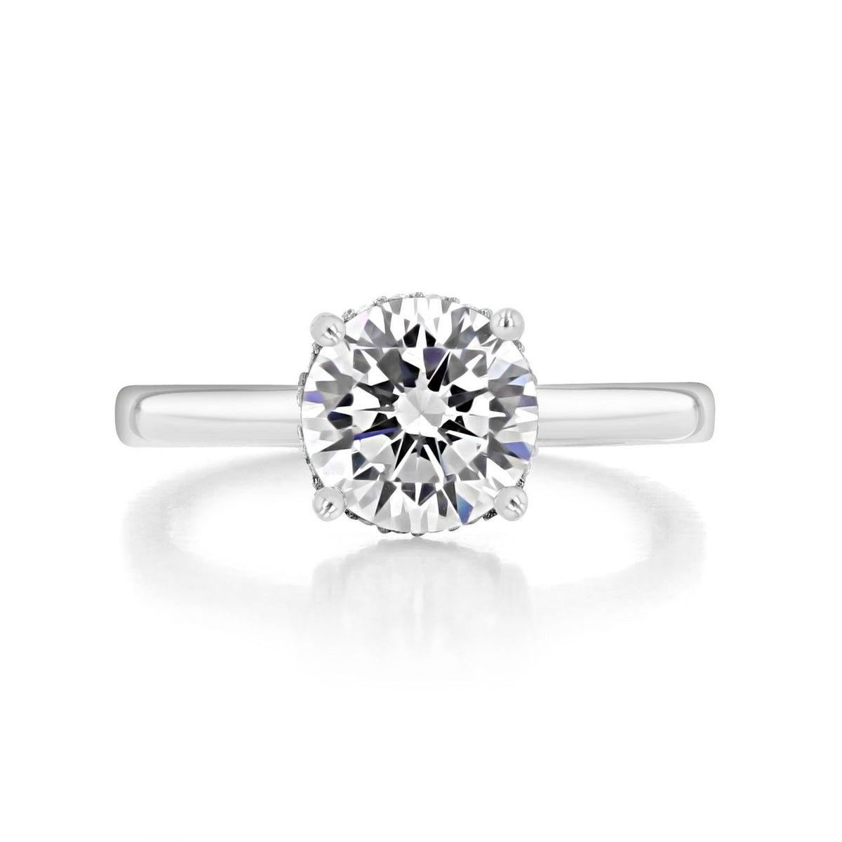 Kaia round solitaire engagement ring by Icing On The Ring featuring a round diamond in a four-prong setting on a plain platinum band.