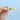 A smooth, gold Coastal Crescent | Diamond Band - P101BFY held between two fingers against a light blue background.