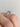 Side profile of a Simply Tacori | Emerald Solitaire Engagement Ring - 2650EC75X55 on a finger, featuring an emerald-cut solitaire and intricate metal detailing along the band.