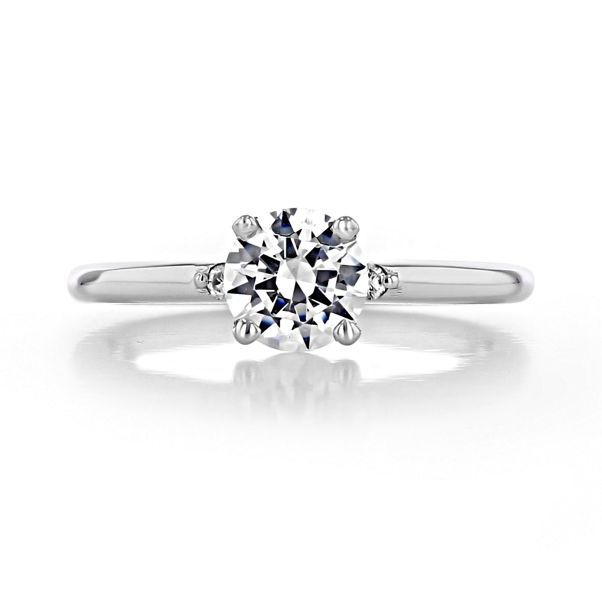 Lacey Round Three-Stone Engagement Ring by Icing On The Ring featuring a silver-toned band with a round center diamond flanked by two smaller round stones.