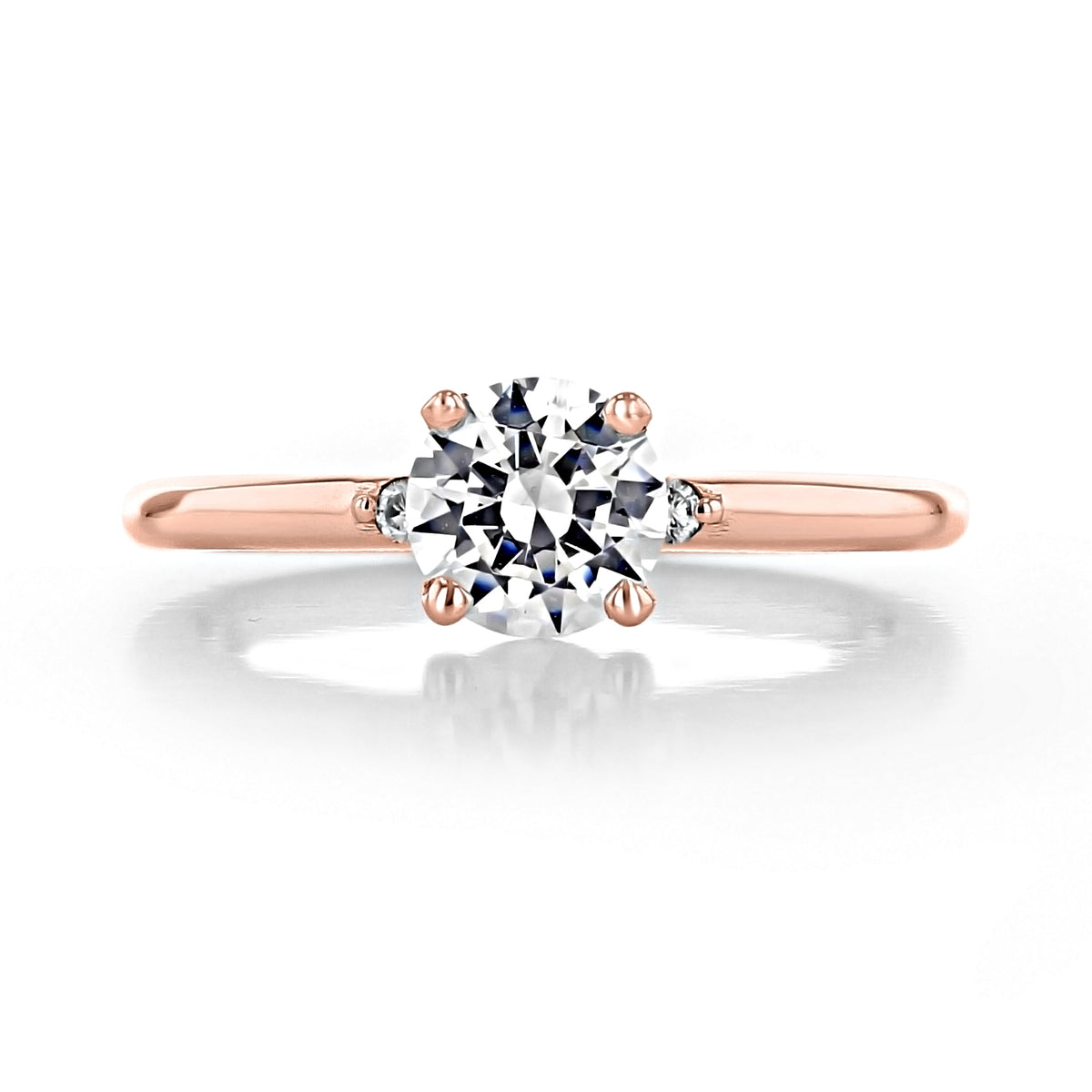 Lacey Round Three-Stone Engagement Ring featuring a 0.50 ct round-cut diamond with two smaller accent stones on a rose gold band.