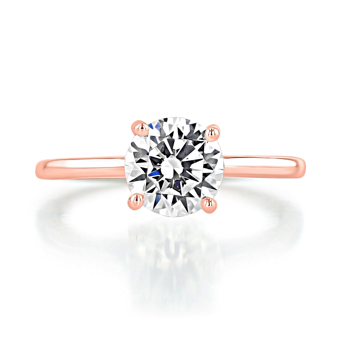 The Icing On The Ring Olympic | Round Solitaire Engagement Ring is a rose gold ring with a round center diamond set in a delicate four-prong hidden halo band.
