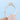 A hand holds an Amara | Round Solitaire Engagement Ring featuring a round stone in a minimal four-prong setting.