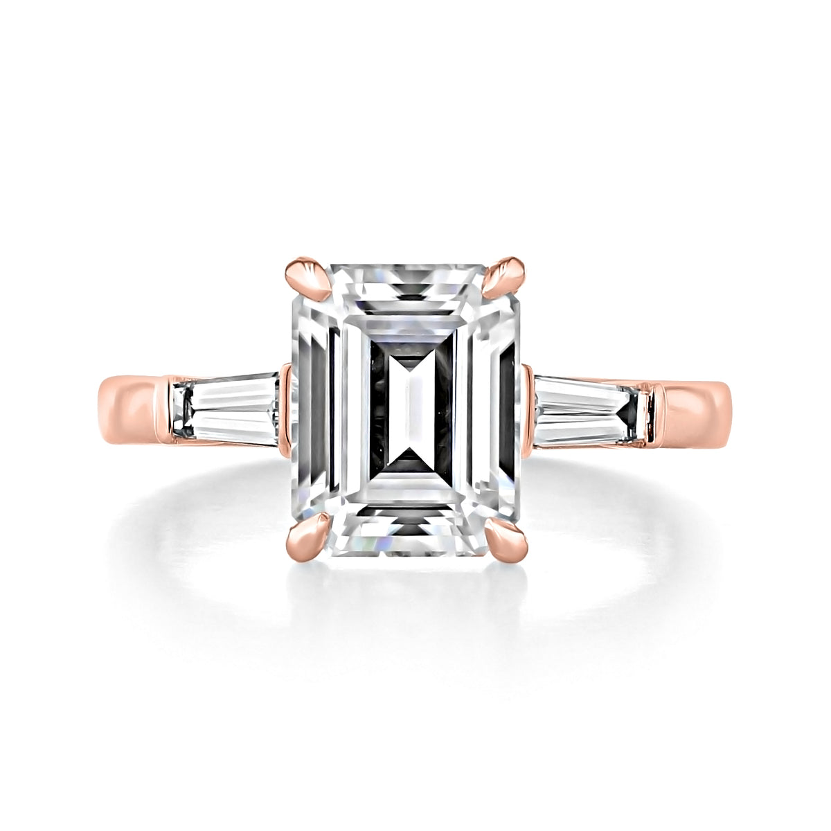 Vivienne Emerald Three-Stone Engagement Ring featuring a large emerald-cut center diamond flanked by two tapered baguette diamonds, set on a 14k rose gold band.