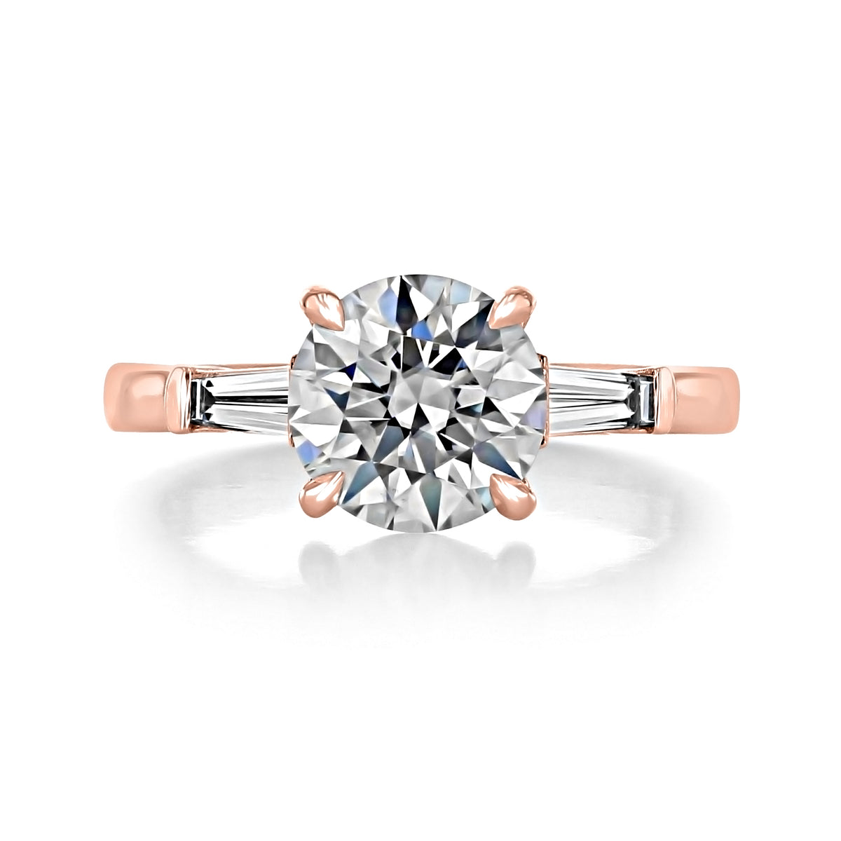Vivienne Round Three-Stone Engagement Ring by Icing On The Ring featuring a round center diamond flanked by a baguette diamond on each side, set on a 14k rose gold band.